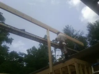 Carpenter setting a ridge beam over a new addition frame — Ice Dam Removal by Roofing Brothers in West Bloomfield